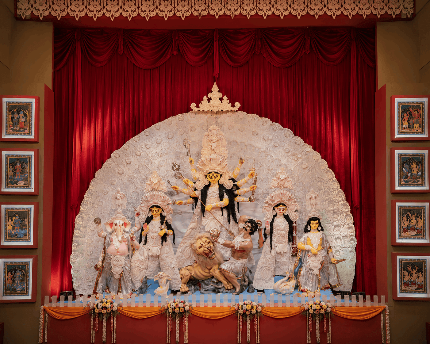 Ornate Durga idol on stage flanked by Patachitra art panels at HCAF Durga Puja