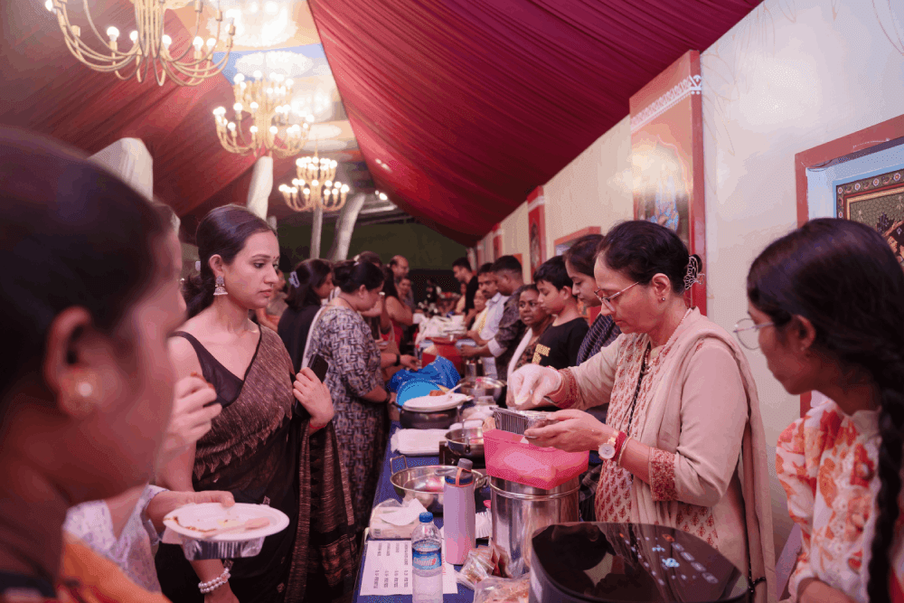 Community food bazaar at Anondo Mela with guests being served home-cooked Bengali food