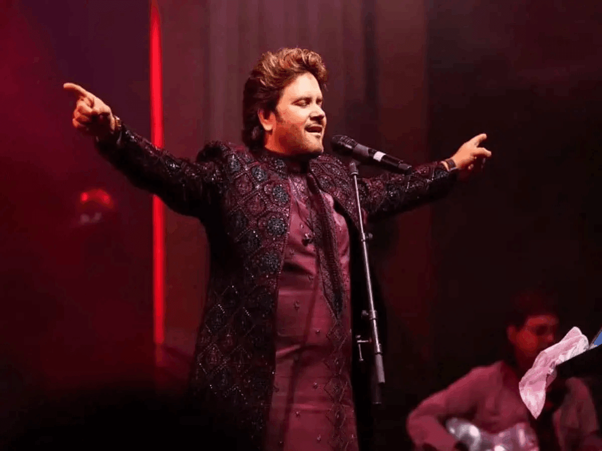 Javed Ali performing live on stage with dramatic red lighting